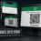 Persona sosteniendo el teléfono frente a la pantalla de una computadora que muestra un código QR de inicio de sesión
