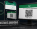 Persona sosteniendo el teléfono frente a la pantalla de una computadora que muestra un código QR de inicio de sesión