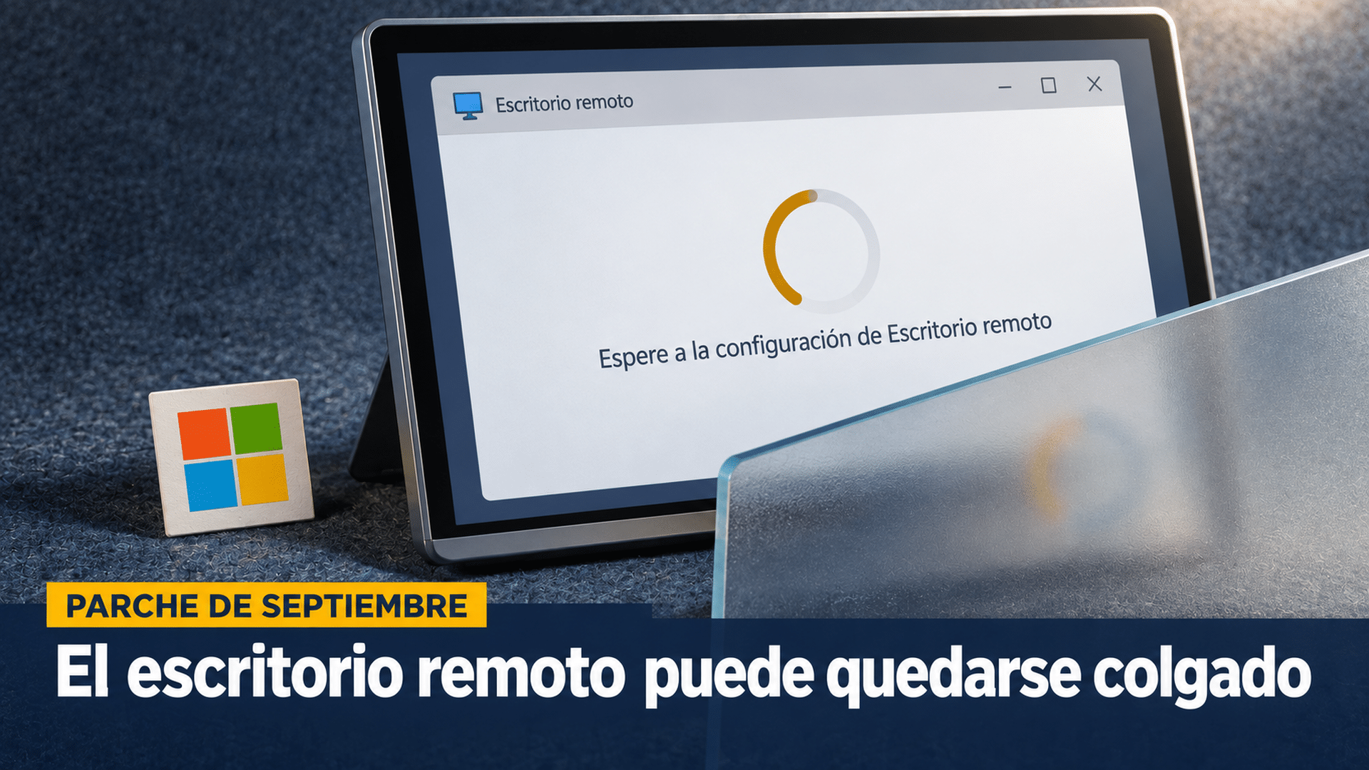 Ilustración con relieve sobre un fondo de fieltro azul grisáceo con textura de tejido: un panel de pantalla apoyado en ángulo, con marco de aluminio y canto grueso visible en el borde inferior, muestra una ventana de conexión remota detenida con un anillo de progreso congelado y la leyenda «Espere a la configuración de Escritorio remoto»; delante, cruzando la esquina inferior, una lámina de acrílico esmerilado traslúcido proyecta su propia sombra, y a un costado se apoya una plaquita con el logo de cuatro cuadrados de Microsoft, fuera de la pantalla; en la banda inferior, el antetítulo «Parche de septiembre» y el titular «El escritorio remoto puede quedarse colgado»